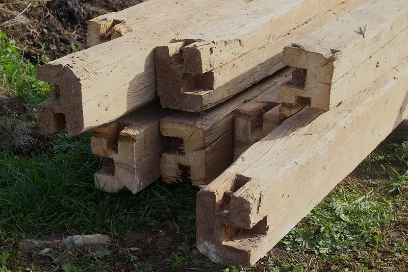 Spoje: čela tesaných trámů s otvory a zářezy po původních spojích