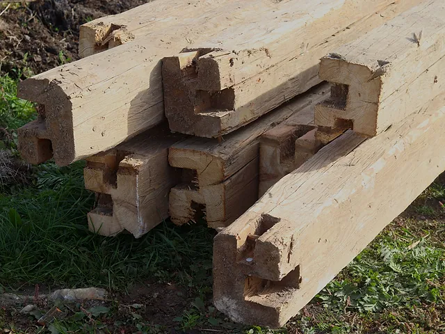 Svazek tesaných trámů se zámky na trávě